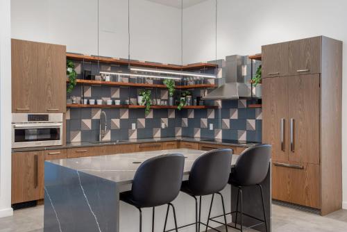 a kitchen with a large island with black chairs at Kasa 2Nd Street Austin in Austin