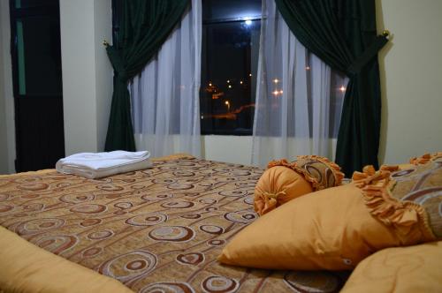 a bedroom with a bed with a window and a pillow at Balcones del Río Hotel in Latacunga