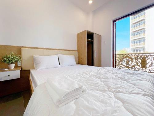 a white bed in a room with a window at Villa Thái An in Phan Thiet