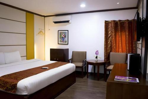 a hotel room with a bed and a table and chairs at Horizon Hotel in Olongapo