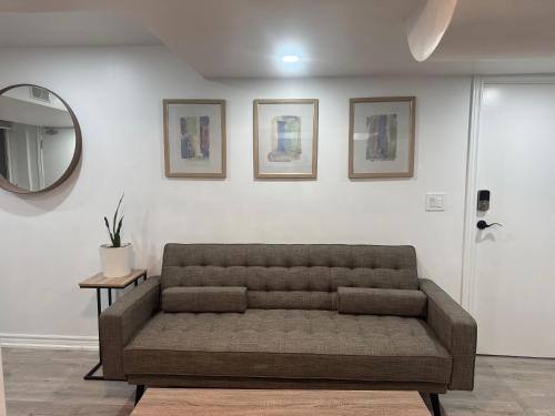 a couch sitting in a living room with a mirror at Peaceful Escape to Town of Lakes in Ajax