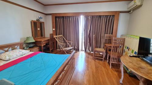 a bedroom with a bed and a table and chairs at Rayong VIP condo Thai style in Ban Phe