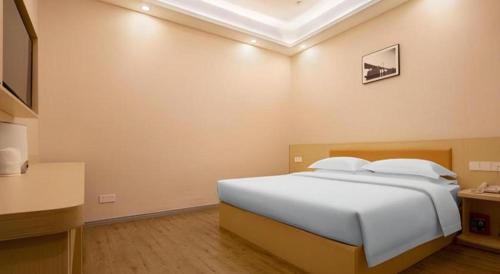 a bedroom with a large white bed in a room at 7Days Premium Yichang Railway Station East in Yichang