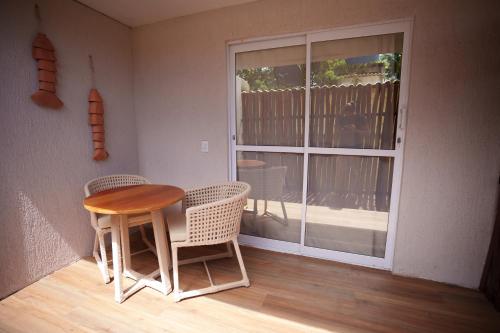 a dining room with a table and chairs and a window at Pousada Aconchego Noronha in Fernando de Noronha
