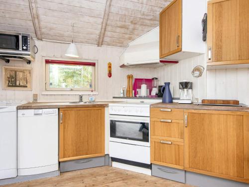 a kitchen with white appliances and wooden cabinets at 5 person holiday home in Hovborg in Hovborg