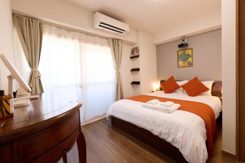 a bedroom with a bed and a desk and a window at Home Story in Tokyo Ueno&Uguisudani-小島ビル&東京屋語 in Tokyo