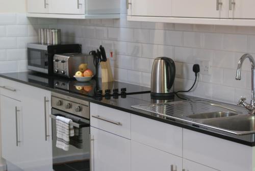 a kitchen with a sink and a counter top at The Glen Mhor Apartments in Inverness