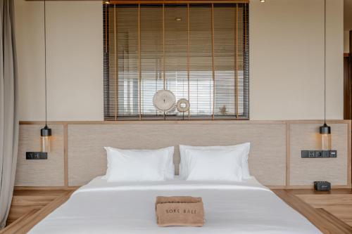 a bedroom with a large white bed and a window at Sore Escape Tumbak Bayuh by Betterplace in Tumbak Bayuh