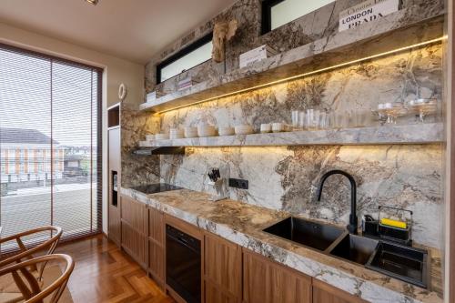 a kitchen with a sink and a stone wall at Sore Escape Tumbak Bayuh by Betterplace in Tumbak Bayuh