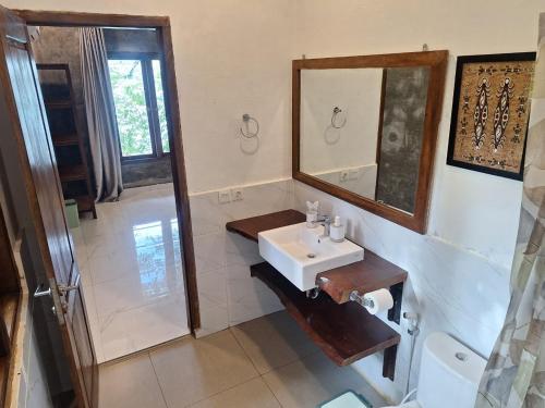 a bathroom with a sink and a mirror at SeaGate Bungalows in Sabong