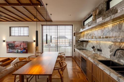 a kitchen with a wooden table and chairs at Sore Escape Tumbak Bayuh by Betterplace in Tumbak Bayuh