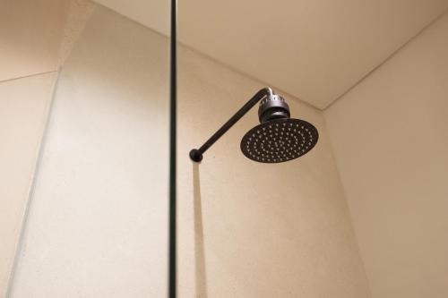 a shower in a bathroom with a shower head at Sore Escape Tumbak Bayuh by Betterplace in Tumbak Bayuh