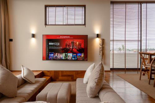a living room with a couch and a tv on the wall at Sore Escape Tumbak Bayuh by Betterplace in Tumbak Bayuh