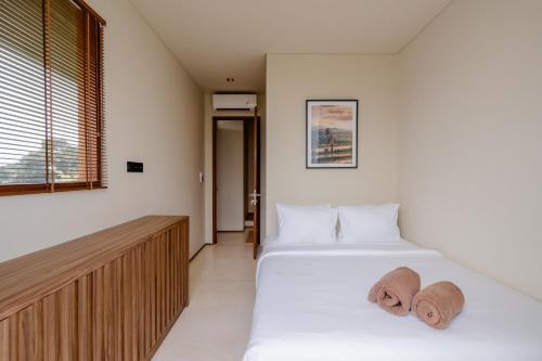 a bedroom with a bed with two towels on it at Sore Escape Tumbak Bayuh by Betterplace in Tumbak Bayuh
