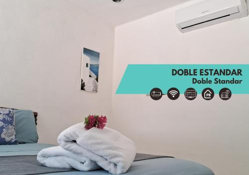 una stanza con un letto con un asciugamano bianco di Hotel Posada Mykonos a Bacalar