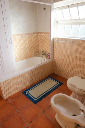 a bathroom with a tub and a toilet and a sink at Casa de Campo, Algarvia in Algarvia