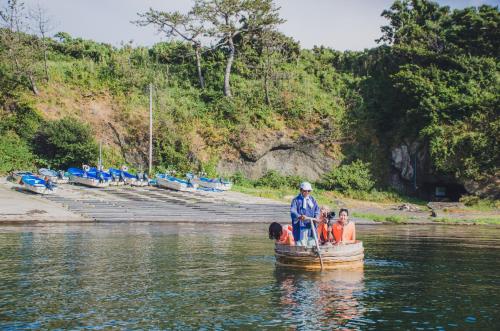 a group of people in a small boat in the water at 佐渡島 築120年の古民家一棟貸切 河崎浪漫館 囲炉裏体験 檜風呂-蔵サウナ完備 in Sado