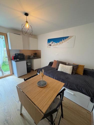 a room with a bed and a table and a bed and a couch at Charmant studio Saint Gervais 74 in Saint-Gervais-les-Bains