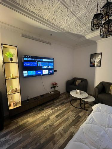 a room with a bed and a tv on a wall at Self-entry studio in Jeddah