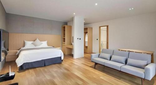a bedroom with a bed and a couch at Hotel Haus in Gapyeong