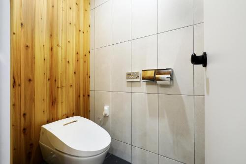 a bathroom with a toilet and a wooden wall at Chuncheon Intro Family hotel in Chuncheon