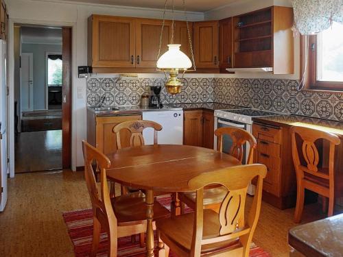 a kitchen with a wooden table and a table and chairs at 7 person holiday home in SKÄRHAMN in Skärhamn