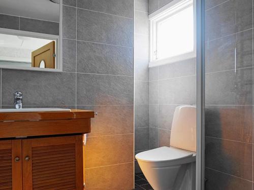 a bathroom with a toilet and a sink and a window at 7 person holiday home in SKÄRHAMN in Skärhamn
