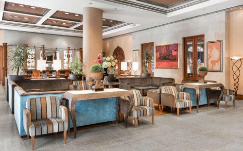 a lobby with chairs and tables and a salon at NH Collection Vigo in Vigo