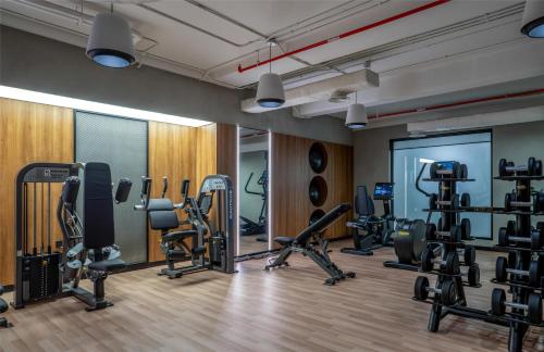 a gym with several treadmills and cardio machines at The Diplomat Radisson Blu Hotel Residence & Spa in Manama