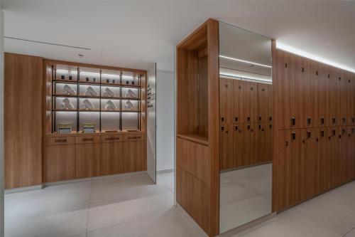 a dressing room with wood paneling and glass cabinets at The Diplomat Radisson Blu Hotel Residence & Spa in Manama