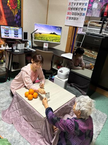 two women are sitting around a table with oranges at エアポートマジカ in Toyonaka