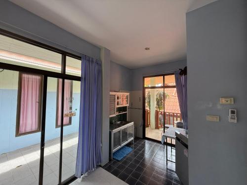 a living room with purple curtains and a view of the ocean at Sawasdee House in Lamai