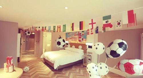 a bedroom with a bed with soccer balls on the wall at Vienna Hotel Chengdu Exhibition Center In Time City in Chengdu