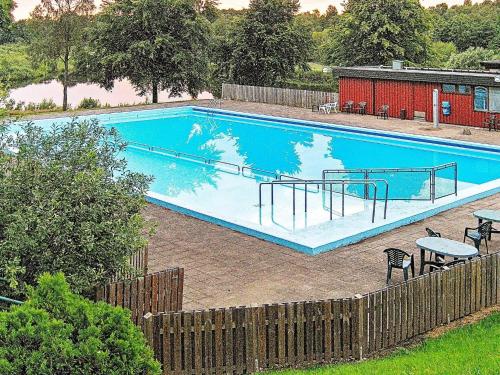 a large blue swimming pool in a yard at 6 person holiday home in TJÖRNARP in Tjörnarp