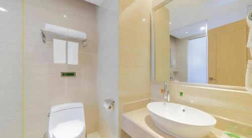 a bathroom with a white toilet and a sink at Vienna Hotel Guangdong Shantou Chaoyang Heping in Shantou