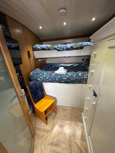 a small room with two bunk beds and a chair at Selene Unique Luxury Houseboat Experience in Chertsey