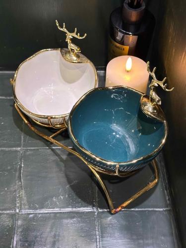 a bath tub with a candle and a sink at Selene Unique Luxury Houseboat Experience in Chertsey