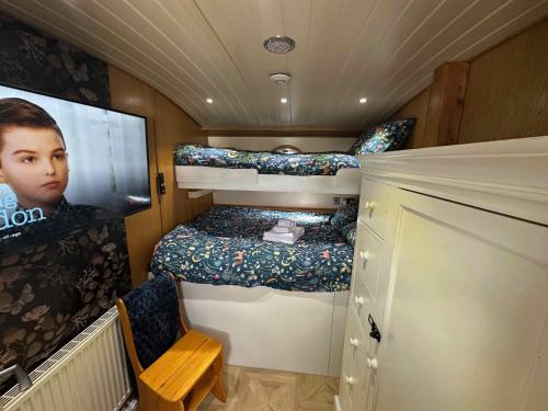 a small room with a bed and a tv in it at Selene Unique Luxury Houseboat Experience in Chertsey
