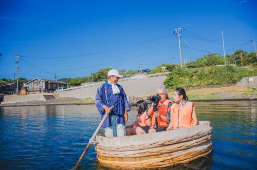 a group of people in a boat on the water at 【佐渡/一棟貸切】オーシャンビュー古民家SeaSideStory椿 離れ in Sado