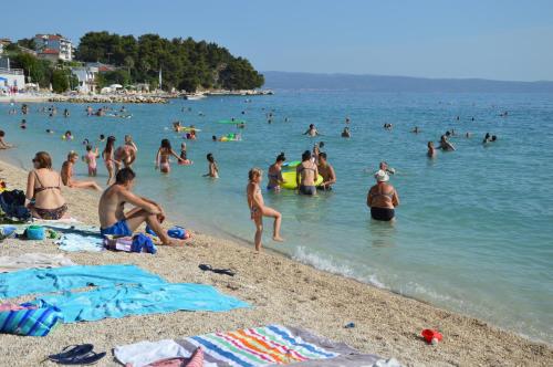 a group of people in the water at a beach at Apartments Babic in Podstrana