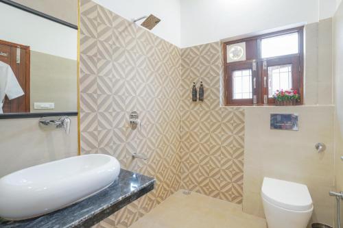 a bathroom with a white sink and a toilet at Classic Bunglow by The StayCationer in Dehradun