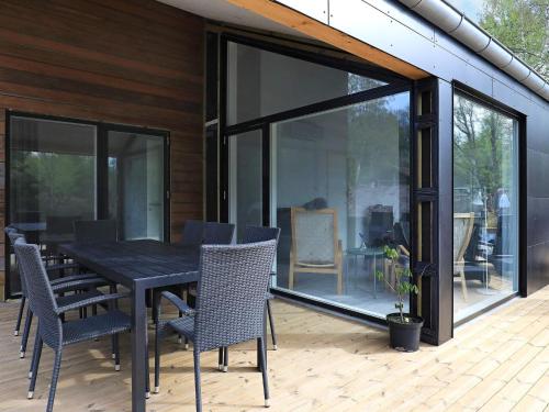 a dining table and chairs on a deck with glass doors at 8 person holiday home in Læsø-By Traum in Læsø
