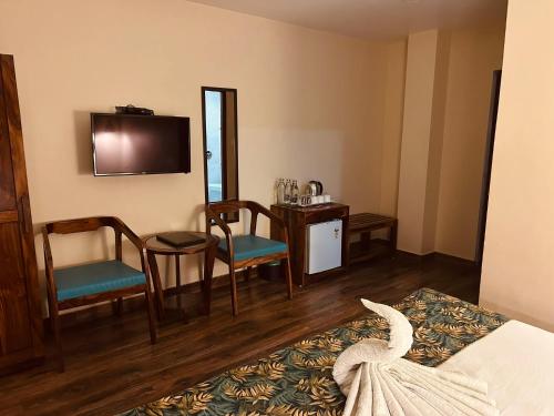 a hotel room with a bed and a table and chairs at SeaScape Port Blair in Port Blair