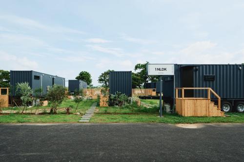 a row of shipping containers parked next to a road at 1NLDK aoshima in Miyazaki