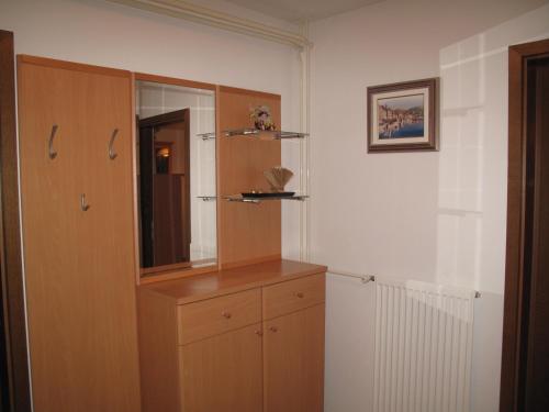 a bathroom with a wooden cabinet and a mirror at Apartma Maržič in Kranjska Gora