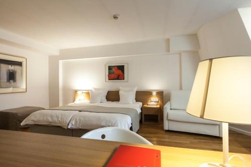 Habitación de hotel con cama y silla en Hotel Simoncini, en Luxemburgo