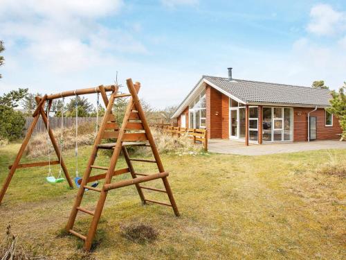 a wooden swing in front of a house at Luxury Eco Cottage in Klitmoller - By Traum Ferienwohnungen in Klitmøller