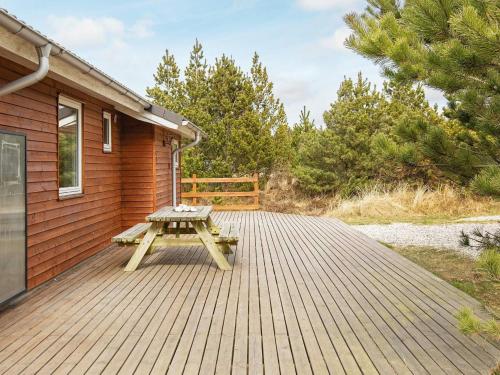 a picnic table on a deck next to a house at Luxury Eco Cottage in Klitmoller - By Traum Ferienwohnungen in Klitmøller