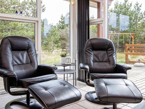 two black leather chairs sitting in a porch at Luxury Eco Cottage in Klitmoller - By Traum Ferienwohnungen in Klitmøller