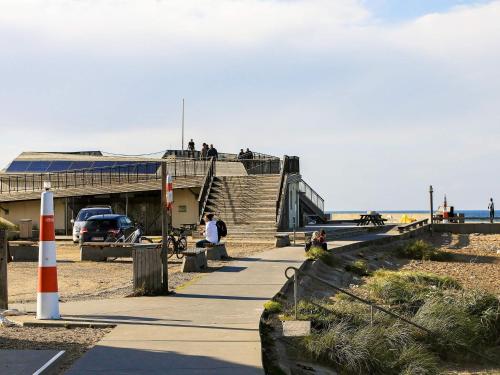 a group of people sitting on a sidewalk near the beach at Luxury Eco Cottage in Klitmoller - By Traum Ferienwohnungen in Klitmøller